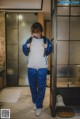 A woman standing in front of a glass door with a backpack.