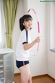 A young woman holding a hula hoop in her hands.