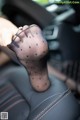 A woman's foot in a car with black polka dots on it.