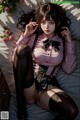 A woman in a pink shirt and black stockings laying on a bed.