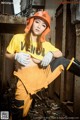 A woman in a yellow shirt and orange hard hat posing for a picture.