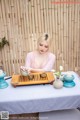 A woman sitting at a table with a tray of tea.