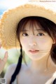 A young woman wearing a straw hat on the beach.