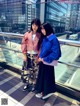 Two young women standing next to each other on a balcony.