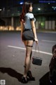 A woman in fishnet stockings is walking down the street.